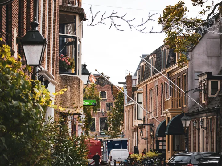 Een geplaveide straat in de binnenstad van Leeuwarden, met bakstenen gevels en lantaarns